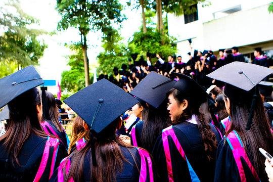 Beautiful Asian university graduates celebrate their success.