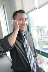asian business man using cellular phone in office