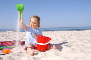baby girl on the beach and blue sky