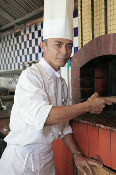 chaf at front of pizza oven at restaurant