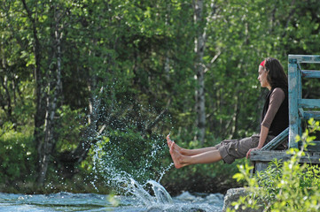 Freshness! Girl playing with river splashes.