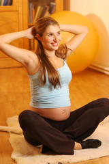 Fototapeta na wymiar A pregnant young woman doing exercises