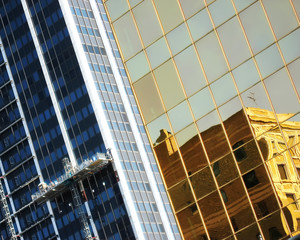 Old building reflecting in new modern building.