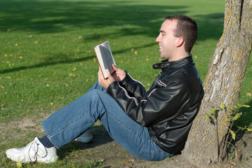 Fototapeta premium A man reading a humorous book outside