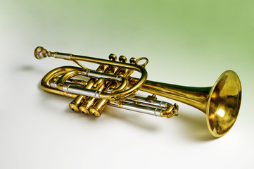 A trumpet containing green reflections in the brass