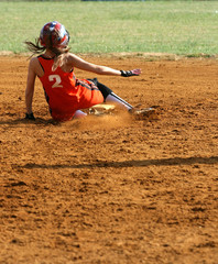 a fastpitch softball player sliding into second base