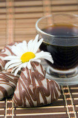 Cup with coffee, cookies and flower