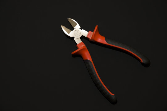 A red forceps on the black background