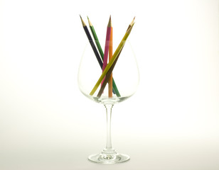 Drawing pencils in the wine glass on white