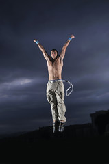 young man dancing and jumping  on top of the building