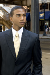 Light brown-skinned black man with pinstriped suit standing