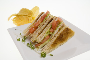 Club Sandwich with crisps against white backround