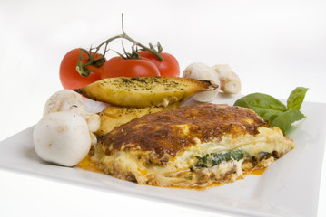 Lasagna and garlic bread with vegetables