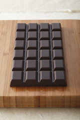 Tafel Schokolade auf Holzbrett