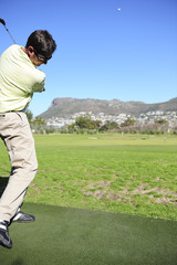 Obraz premium A golfer in action on a practice or driving range.