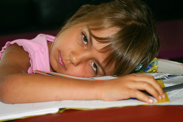 petite fille épuisée sur les devoirs