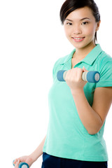 Naklejka premium A young attractive Asian woman in sportswear with dumbbells