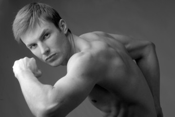 young guy of an athletic constitution does sports exercises