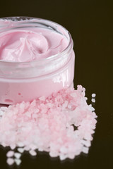 Pink rich bodycream with pink bath salt in front