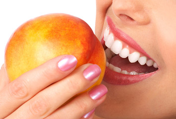 Beautiful young woman eating a peach. Isolated over white.