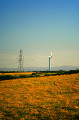 A photography of a power pole and wind mill