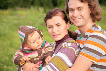 Fototapeta na wymiar family with baby in stripe clothes in park