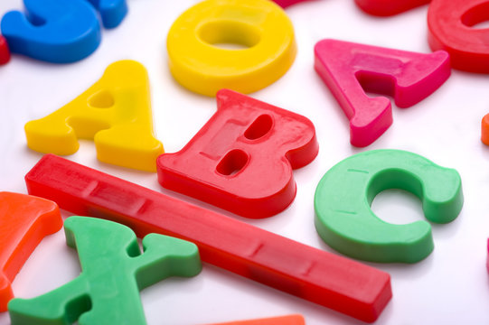 Brightly colored plastic alphabet letters on a white background