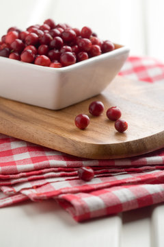 Fresh cranberries in white bowl, selective focus