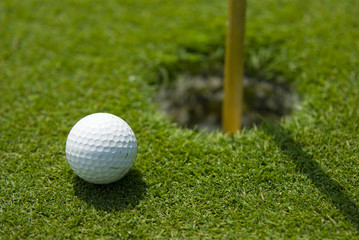Golf club view of Golf ball in the putting green - sport