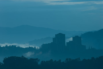 Misty morning of high rise buildings on hilly residential area.