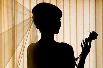 silhouette of bride is holding flower of rouse