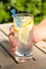 Hand holding glass of Gin and Tonic