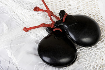 Black spanish castanets on a white shawl