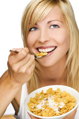 young beautiful woman eating corn flakes close up