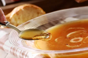 Selbstklebende Fototapete Vorspeise Zwiebelsuppe löffeln