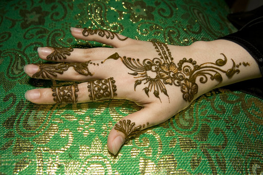 Beautiful wet henna design on a Muslim woman's hand .