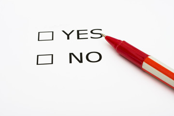 Paper with boxes with the words yes and no with a pen, voting