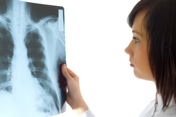 Female doctor looking at x-ray image on white