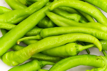 Green peppers in the plate isolated on white