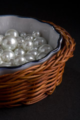 Basket with white pearls isolated on a black background