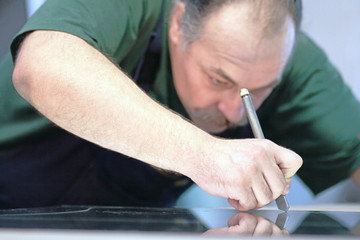 The worker, cutting a mirror,fokus on a hand