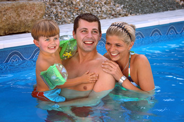 Junge Familie mit einem Kind im Pool