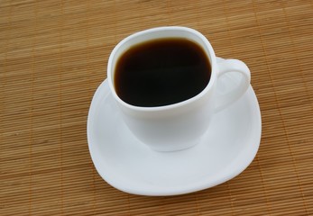 White cup of coffee on wooden background