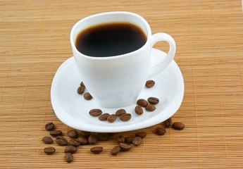 White cup of coffee with coffee grains