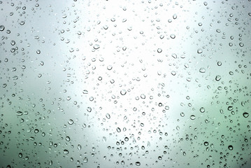 rain drops on a window and mystic silhouette of city