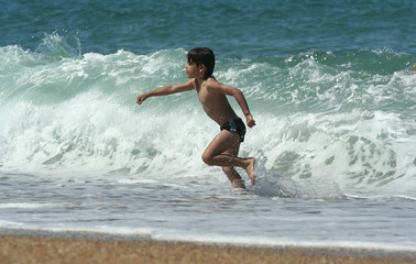 enfant en train de courir dans les vagues