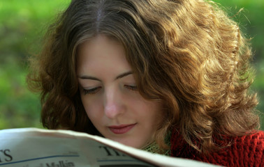 Girl is reading newspaper