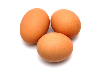 Three chicken eggs on a white background largly
