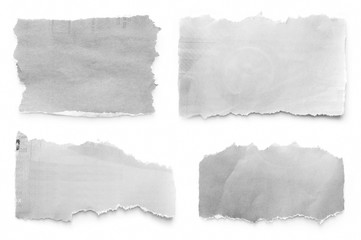 Newspaper tears collection, casting natural shadow on white.