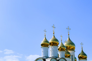 Fototapeta na wymiar Golden church domes on blue sky background